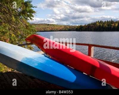 Un rosso e blu kayak su un dock con colori autunnali intorno a loro sulla st John fiume new brunswick canada Foto Stock