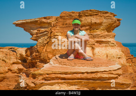 Un giovane turista pone contro il rosso colorate formazioni geologiche A Gantheaume Point vicino Broome Australia Occidentale Foto Stock