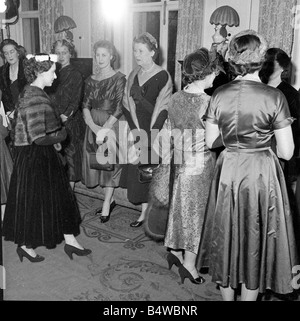 La regina madre e la principessa Margaret visto qui al salone di abbigliamento designer Hardy Amies chiacchierando con i modelli a seguito di una sfilata di moda;Dicembre 1954;RI8668; Foto Stock