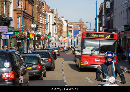 Traffico e negozi nella trafficata Putney High Street London Foto Stock