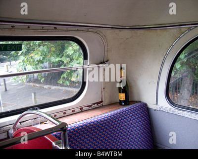 Svuotare la bottiglia di champagne a sinistra sul bus Foto Stock