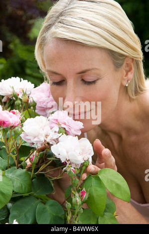 Donna odore di rose Foto Stock