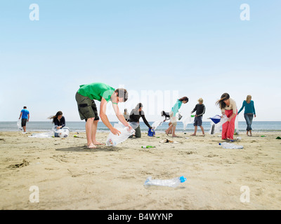 Giovani raccogliere rifiuti sulla spiaggia Foto Stock