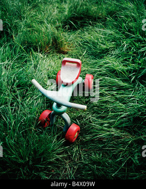 Bambino abbandonato il trike in erba Foto Stock