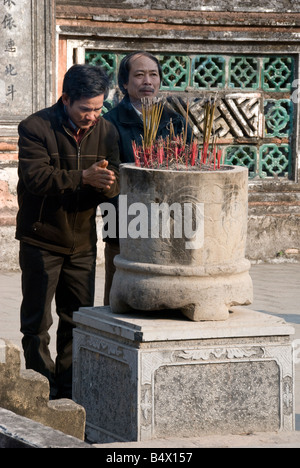 Sollevare gli adoratori joss bastoni per gli spiriti del re Le, un monarca precoce del Vietnam, a Le Dai Hanh tempio, Hoa Lu Foto Stock