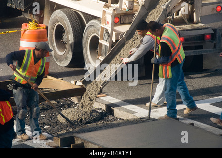 Lavoratori versare il cemento in stampo di un nuovo marciapiede. La foto  mostra il movimento del cemento o del calcestruzzo Foto stock - Alamy