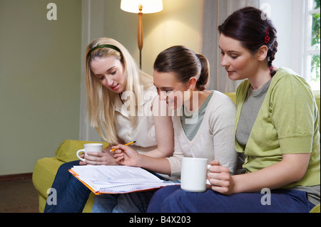 Tre giovani donne seduta sul lettino Foto Stock