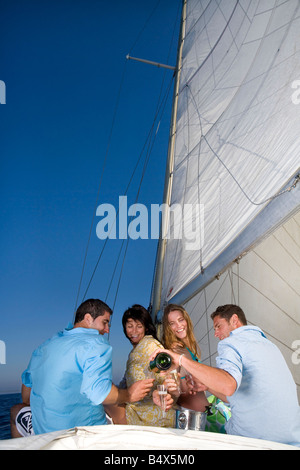 Le coppie facendo un brindisi sulla barca a vela Foto Stock