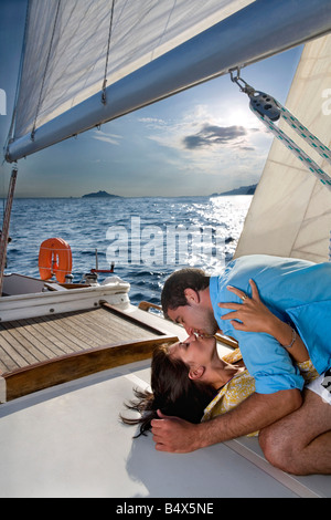 Giovane posa sulla barca a vela, kissing Foto Stock