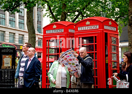 Telefono rosso casella stand l uomo è la lettura di un piano di terra mappa Foto Stock