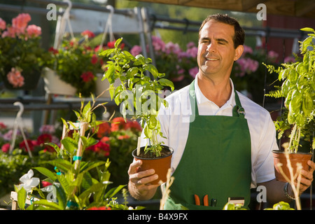 Uomo al lavoro nel centro giardino Foto Stock