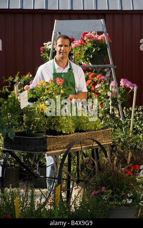 Uomo al lavoro nel centro giardino Foto Stock