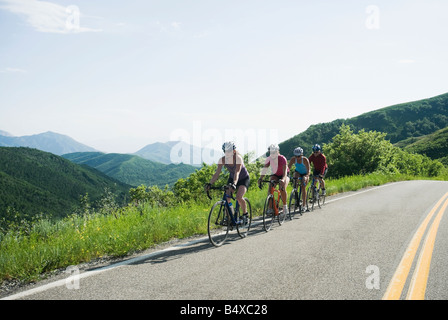 I ciclisti in una fila sulla strada di montagna Foto Stock