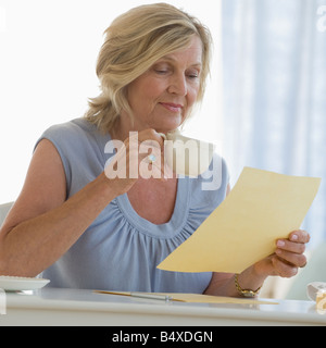 Donna lettura la lettera a casa Foto Stock