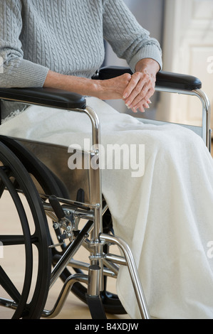 Senior donna seduta in carrozzella Foto Stock
