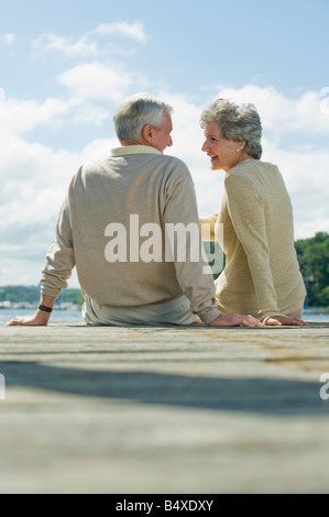 Coppia senior seduti sul dock Foto Stock