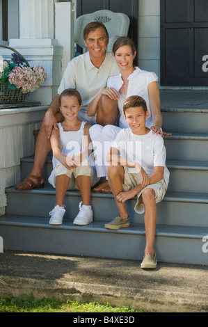 Famiglia seduti sulla parte anteriore stoop Foto Stock