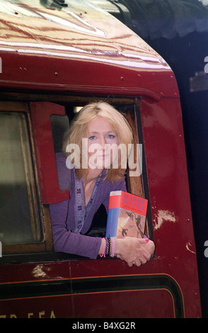 J K Rowling autore si appoggia al di fuori di un treno a vapore chiamato Hogwarts Express a Kings Cross stazione ferroviaria a Londra mentre tiene il suo quarto libro nel popolare i bambini s serie di Harry Potter Harry Potter e il calice di fuoco questo treno appare nel libro di Potter con il nuovo titolo di andare in vendita in tutto il mondo a sabato Foto Stock