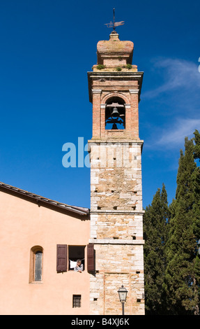 Donna che guarda fuori dalla finestra della la chiesa Collegiata, San Quirico, Valle de Orcia, Toscana, Italia Foto Stock