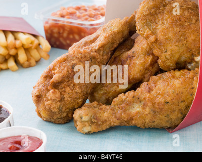 Il pollo fritto in una scatola con le patatine fritte, fagioli al forno, Coleslaw e salse Foto Stock