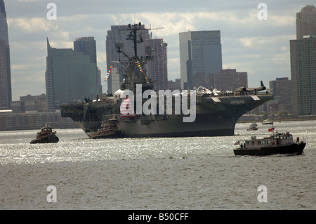 La Intrepid Sea Air Space Museum è trainato fino al Fiume Hudson su di esso s viaggio di ritorno per il suo molo Foto Stock