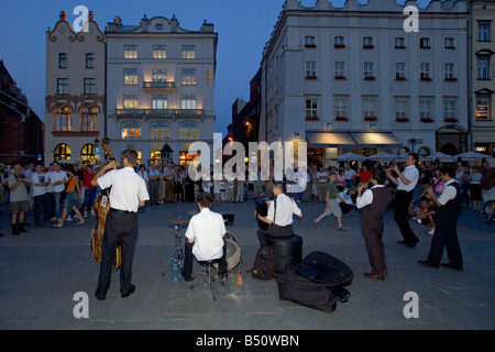 Artisti di strada a giocare nella Piazza del Mercato di Cracovia al crepuscolo. Foto Stock