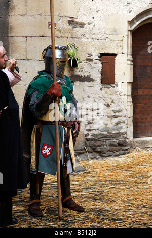 Un cavaliere medievale in piedi in strada a Estaing Foto Stock