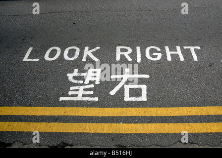 Guardare a destra segno su asfalto in cinese Foto Stock