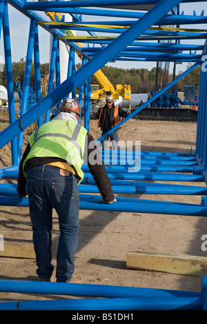 Lavoratori assemblare gru usate per sollevare le lame su di una turbina eolica Foto Stock