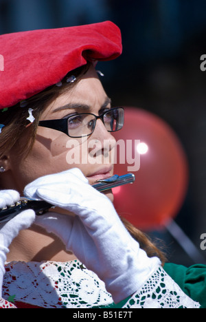 Una giovane donna musicista suona il flauto nell'annuale Sagra des Vendanges parade Showband Les Armourins Foto Stock