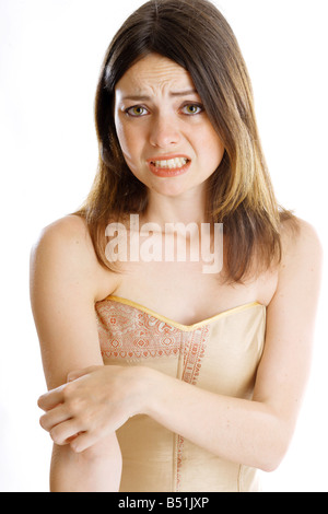 Giovane donna di graffiare il suo braccio superiore Foto Stock