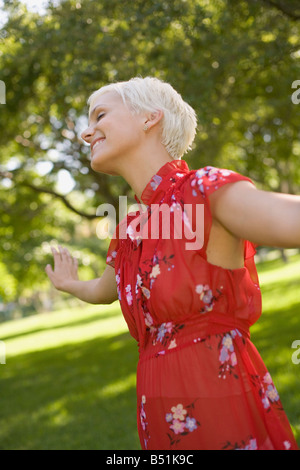 Donna con le braccia tese in posizione di parcheggio Foto Stock