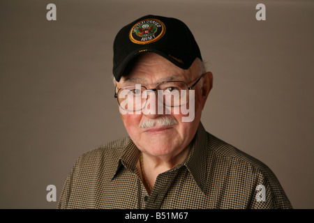 Anziani American II Guerra Mondiale veterano tenendo una bandiera americana e indossando un esercito degli Stati Uniti cap. Foto Stock