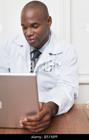Medico seduto alla scrivania che lavora sul computer portatile Foto Stock