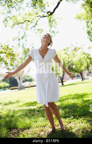 Donna che indossa abito bianco in posizione di parcheggio Foto Stock