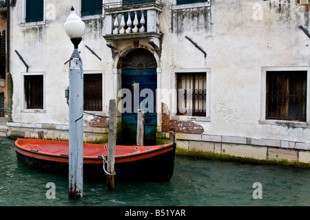 Rosso barca fuori casa veneziana con porta blu sul Canal Grande Venezia Veneto Italia Europa UE Foto Stock