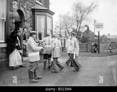 A Goathland slot aratro Yorkshire County dance team di eseguire la cerimonia antica di ballo prima di ogni casa di villaggio di Goatland, Yorks. L'Aratro a Goathland slot sono un raro esempio di quella che una volta era una diffusa tradizione rurale che ha riconosciuto l importanza dell'aratro e celebrata con la spada danza, musica e giochi popolari. Tradizioni simili sono noti per avere esisteva in altre parti dello Yorkshire, Lincolnshire, Derbyshire e Northumberland, dove erano conosciuti come "l'aratro Boys', 'giovenco Lads', 'Ploo brocche' aratro (Jack) e 'Fond o ingannare aratro'. Gennaio 1950 022214/1 Foto Stock