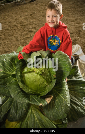 Ragazzo giovane pone con i suoi 69 pound il cavolo in Alaska State Fair, Palmer, Alaska Foto Stock