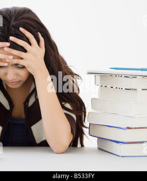 Centro Donna orientale con testa in mani accanto ai libri Foto Stock