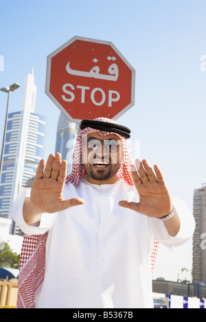 Uomo arabo che sta sotto il segnale di arresto Foto Stock