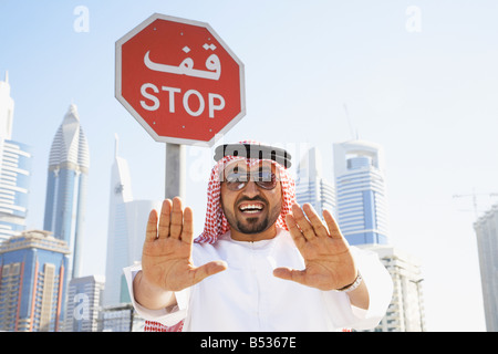 Uomo arabo che sta sotto il segnale di arresto Foto Stock