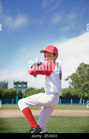 Razza mista boy pitching nel gioco di baseball Foto Stock