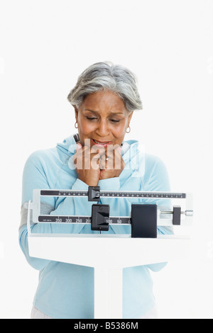 Donna africana del peso di se stessa su scala Foto Stock