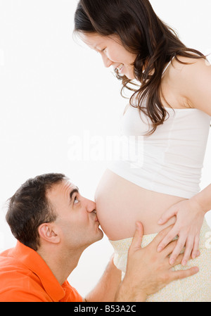 Il marito baciare moglie incinta lo stomaco Foto Stock