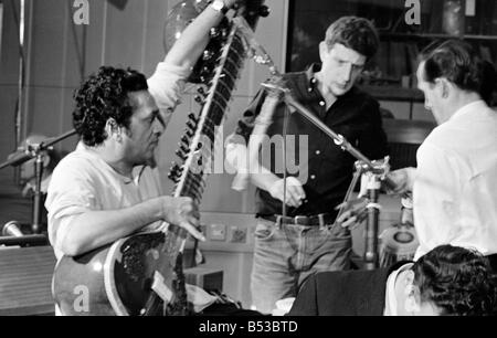 Ravi Shankar giocando il sitar in un BBC sound studio al Centro Televisivo Città Bianca Produttore Jonathan Miller può essere visto nella musica di sottofondo musicista di strumento musicale prestazioni indiano Recording Studio Ottobre 1966 Mirrorpix Mirrorpix Foto Stock