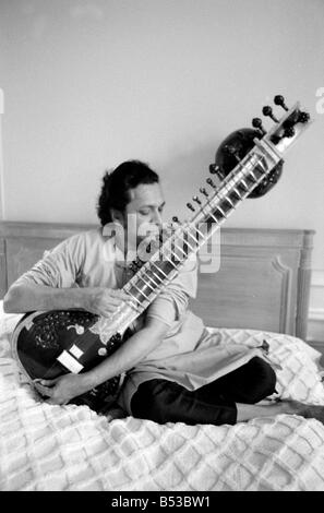 Ravi Shankar giocando il sitar nella sua suite presso il Savoy Hotel seduta sul letto musicista musica strumento musicale prestazioni indiano Ottobre 1969 Mirrorpix Foto Stock