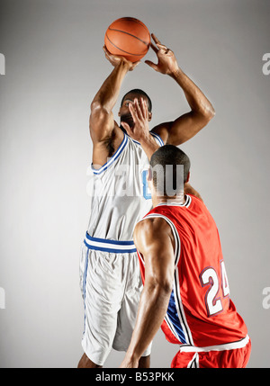 Giocatore di basket cercando di prendere la pallacanestro da avversario Foto Stock
