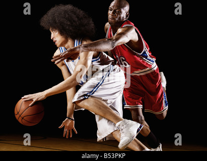 Giocatore di basket cercando di prendere la pallacanestro da avversario Foto Stock
