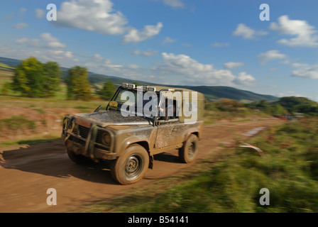 Terreni fangosi Land Rover Defender 90 Softtop accelerando su una pista forestale nel Weserbergland. Foto Stock