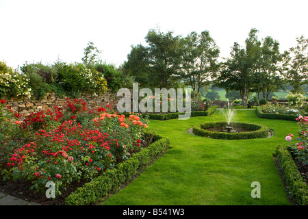 Una funzione di acqua con una fontana in una formale del giardino delle rose Foto Stock